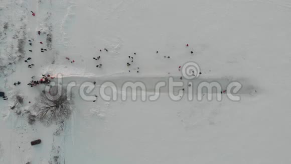 在雪地滑梯上快乐的孩子冬天穿着塑料雪橇从白山上骑下来的小男孩视频的预览图
