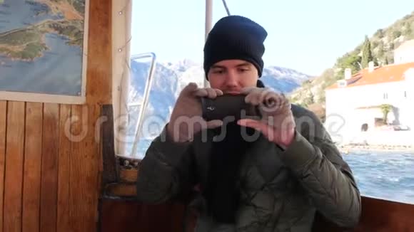 英俊的微笑青年游客在船上录制视频视频的预览图