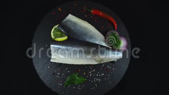 鱼片鲱鱼和香料黑色背景旋转360度俯视视频的预览图