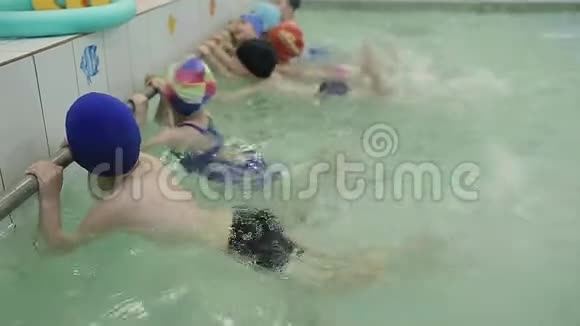 孩子们在游泳池里学习游泳孩子们在水中踢脚造成水在水中的飞溅视频的预览图