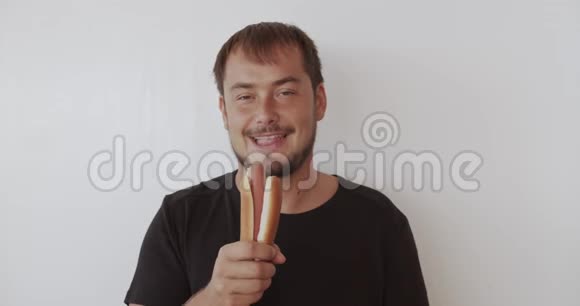 快乐的男人咬着美味的热狗微笑着视频的预览图