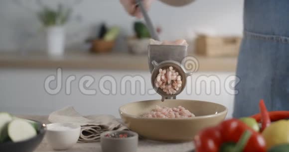 厨师在厨房的机械磨床上磨碎肉饼烹饪减肥肉火鸡肉末视频的预览图