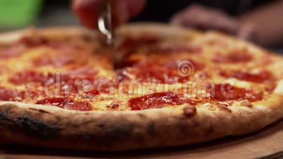 厨师用比萨饼刀切披萨鲜辣辣香肠配软干酪和烤皮视频的预览图