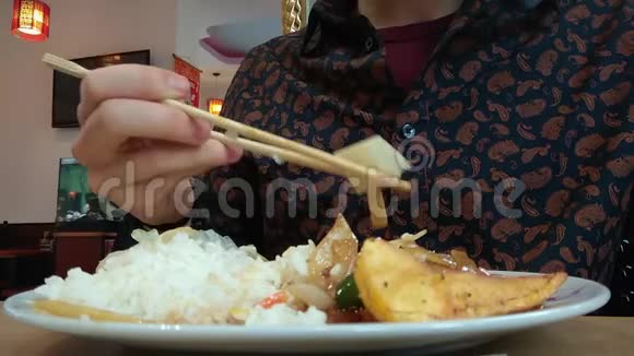 在亚洲餐馆吃饭使用筷子细节衬衫低角度氛围视频的预览图