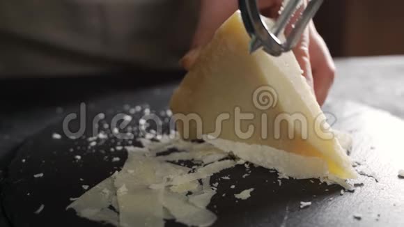 帕尔马干酪成分在木切割板上一只手拿着刀折断几块来细细品味视频的预览图
