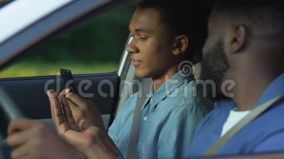 焦急的黑爸爸抓住儿子智能手机试图控制青少年冲突视频的预览图