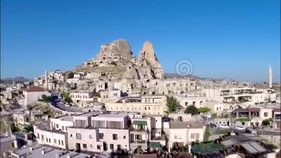 在巨大的沙石岩峡谷沙漠上的小城市房屋上的壮观空中全景景观视频的预览图
