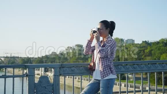 清晨站在桥上拍摄复古镜头的美女视频的预览图
