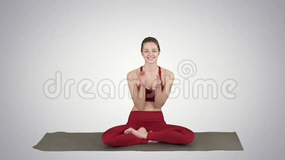 积极开朗的年轻女性在瑜伽姿势拍手和微笑的梯度背景视频的预览图