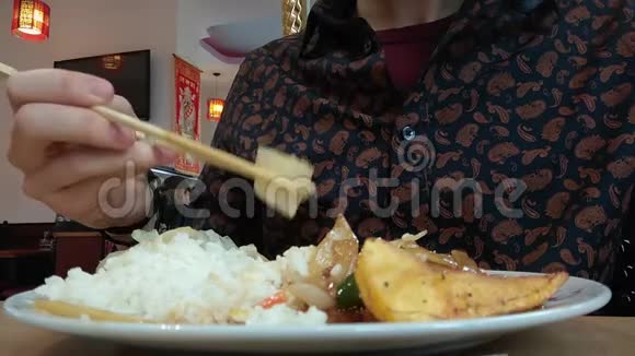 在亚洲餐馆吃饭手拿筷子衬衫图案衬衫低角度氛围视频的预览图