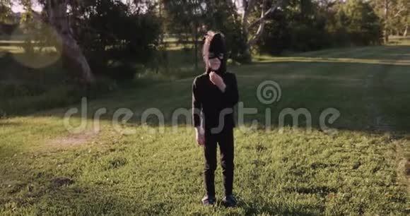 小男孩戴着自制的忍者面具和黑色服装练习忍者动作忍者做侧踢视频的预览图