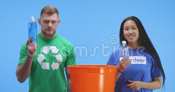 有环保意识的男人和女人把瓶子放进桶里视频的预览图