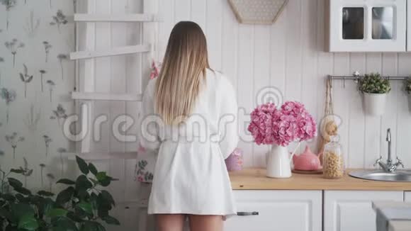 厨房里穿着浴袍的年轻女人拿着一篮子面包选择更新鲜的视频的预览图