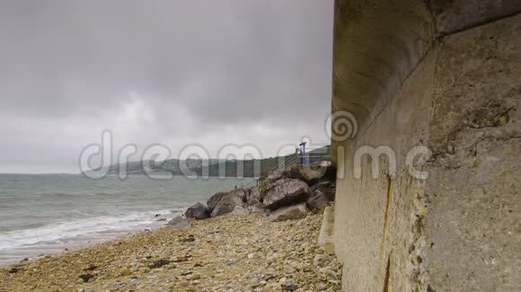 一片岩石海滩与厚厚的混凝土墙相连视频的预览图
