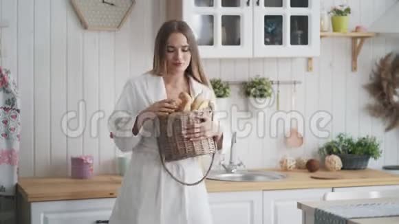 厨房里穿着浴袍的年轻女子带着一篮子新鲜面包跳舞视频的预览图
