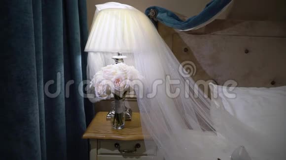 卧室里放着白色玫瑰花和面纱的婚礼花束视频的预览图