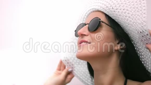 美丽的时尚笑脸女游客戴着时髦的太阳镜和帽子放松视频的预览图