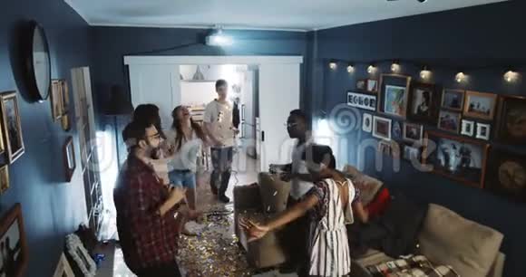 高角度拍摄快乐多民族大学生一起跳舞在娱乐室聚会享受假期慢动作视频的预览图