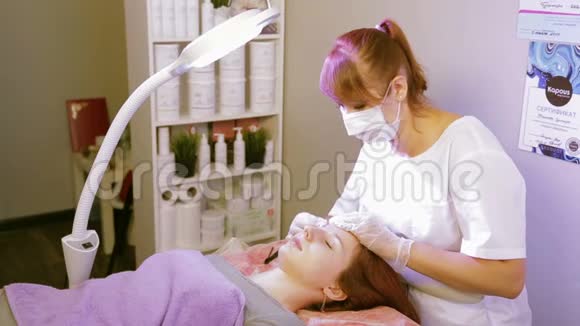 美容师在矫正前用消毒液擦拭病人的眉毛视频的预览图