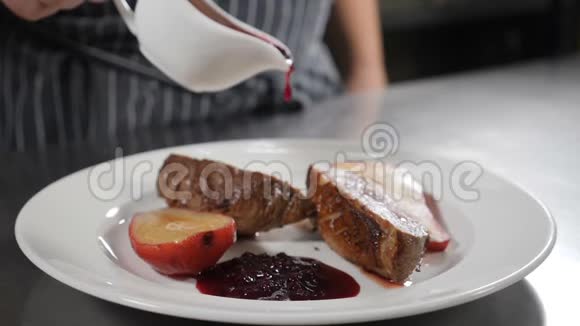 慢动作食物视频提供餐厅菜肴厨师拿着白色的肉汁船和红莓酱浇注视频的预览图