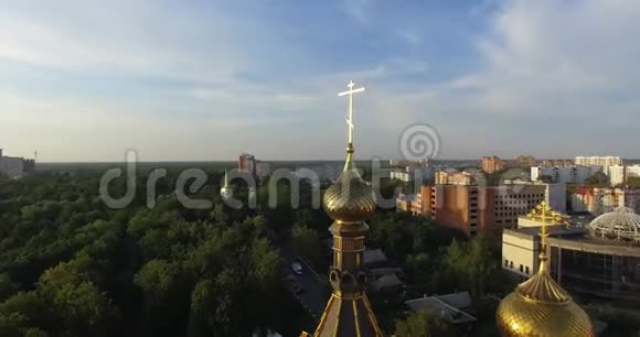 俄罗斯东正教教堂金色圆顶日落时的空中城市景观视频的预览图