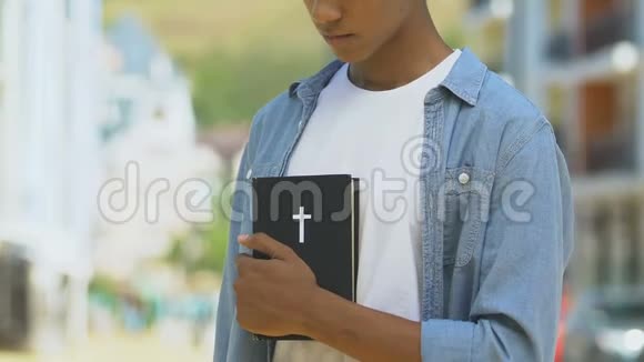 愤怒的男孩拿着圣经思考宗教正义的生活皈依视频的预览图