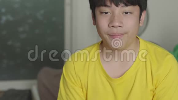 亚洲男孩看电影和吃爆米花在家享受视频的预览图