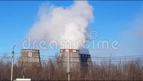 工业区有大管道的冷却塔有一股白色的浓烟在一个大城市的火电站工作视频的预览图