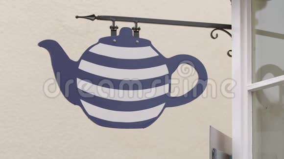一个茶壶标牌悬挂在室外支架上视频的预览图