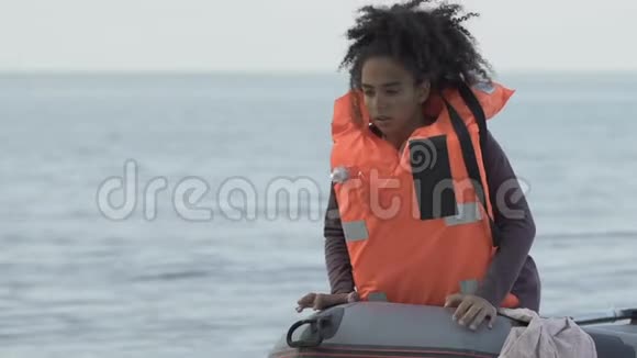 失踪的黑人女孩脱下救生衣在沉船后停泊在岸上视频的预览图