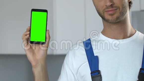 有魅力的修理工演示绿色屏幕智能手机到相机应用程序视频的预览图