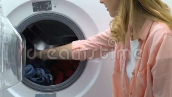 女士从洗衣机里拿出牛仔夹克闻了闻厌恶视频的预览图
