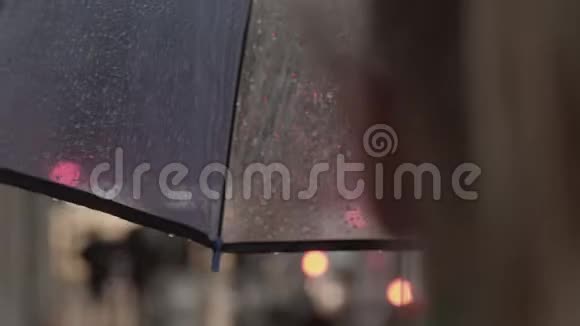 女人在雨市的伞下行走视频的预览图