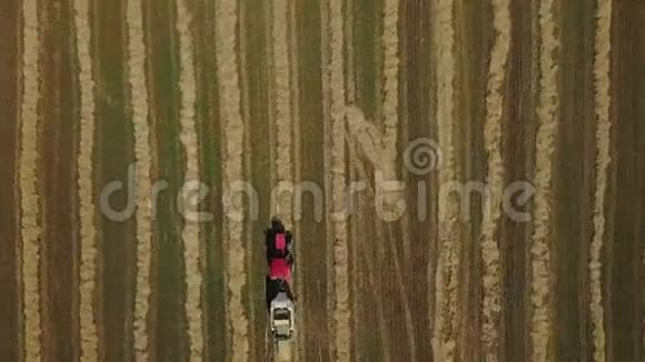 用拖拉机做干草立方体的无人机射击农业机械在阳光明媚的日子里喷射干草视频的预览图