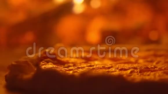披萨在烤箱里有一个脆皮和起泡奶酪在背景下火在烤箱里燃烧射击视频的预览图