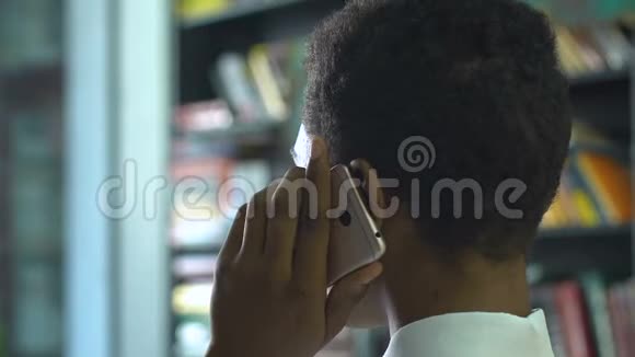 聪明的学生在手机书架背景上同意面试视频的预览图