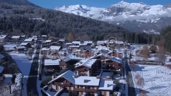 在白雪覆盖的冬松林阿尔卑斯山脉景观中豪华的小别墅宽敞舒适视频的预览图