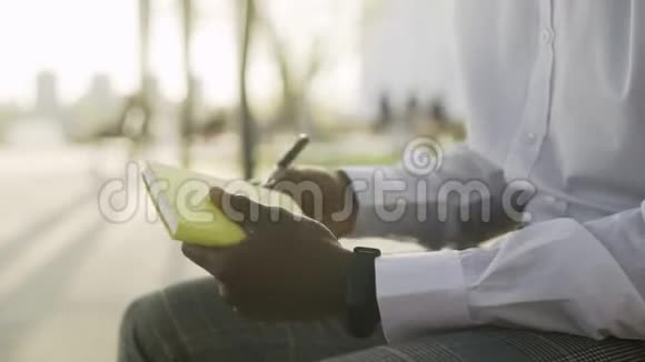 年轻的非洲商人正在公园里休息看书视频的预览图