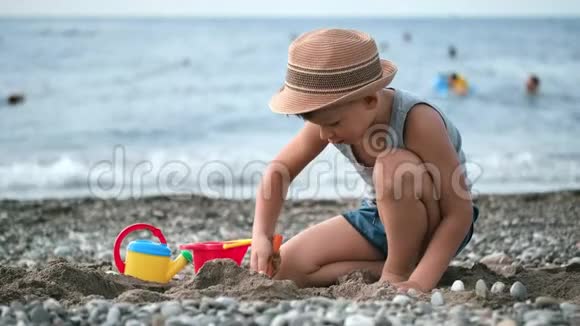 小可爱的男孩在海滩上玩沙子玩玩具享受暑假活动视频的预览图