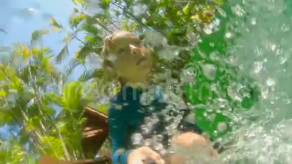 小男孩vlogger在一个水上公园的滑梯上拍摄了一个自拍视频慢镜头视频的预览图