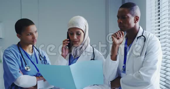 中东女医生与医院同事用手机交谈的正面看法视频的预览图