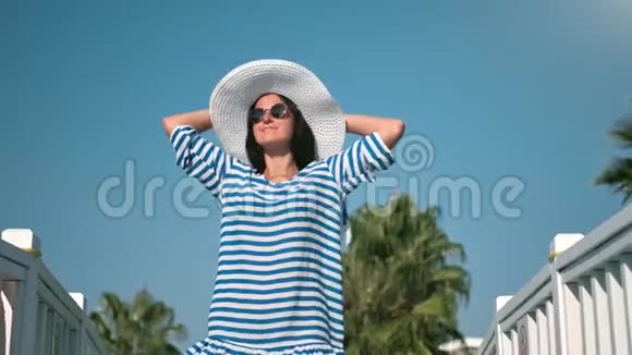 时尚的旅游女性戴着时髦的太阳镜戴着帽子跳舞放松心情有积极的情绪视频的预览图