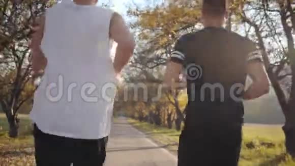 两个穿着运动装的白人男孩在秋季公园跑步准备比赛的运动员视频的预览图