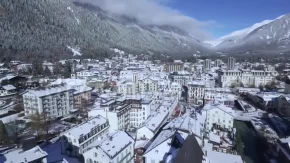 美丽的豪华度假酒店别墅舒适的小屋村在白雪覆盖的冬季森林阿尔卑斯山的山景视频的预览图