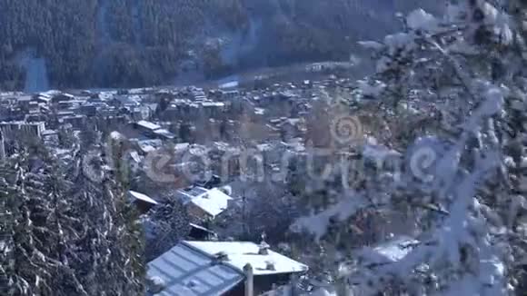 在阿尔卑斯山脉松树冬林中的豪华度假村舒适别墅中不可思议的无人机空中景观视频的预览图