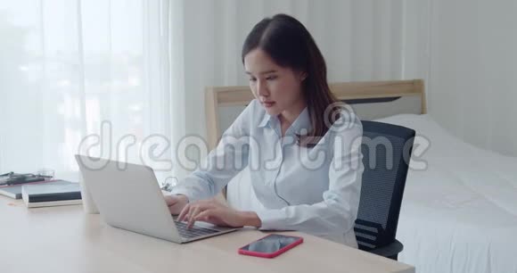 肖像年轻美女使用笔记本电脑和智能手机视频的预览图
