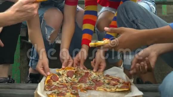 多种族青少年朋友吃美味的披萨片户外小吃快餐视频的预览图