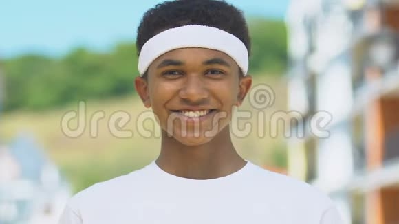 黑色男性跑步者带着头带微笑进入镜头运动生活方式医疗保健视频的预览图