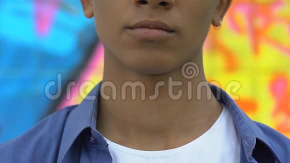 自信的青少年男性戴着耳环在镜头上微笑时尚和自由视频的预览图