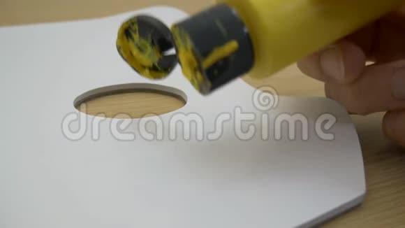 在木桌上的白色薄片上涂上丙烯酸黄色油漆视频的预览图
